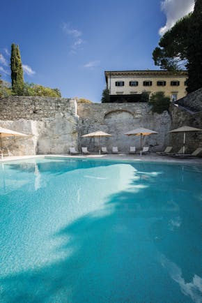 Borgo Pignano Tuscany pool sun loungers umbrellas 