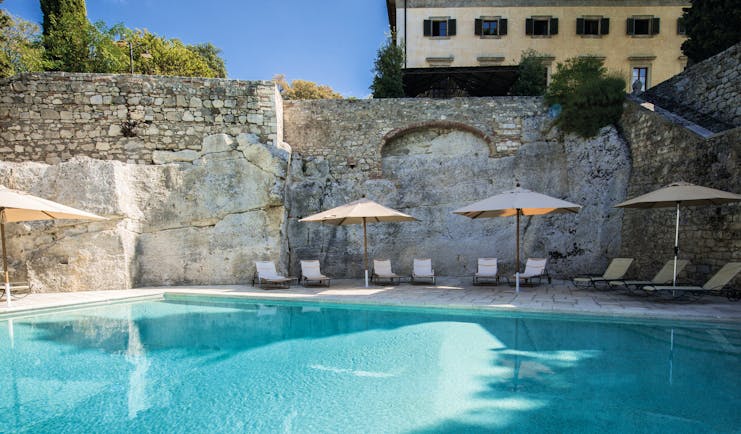 Borgo Pignano Tuscany pool sun loungers umbrellas 