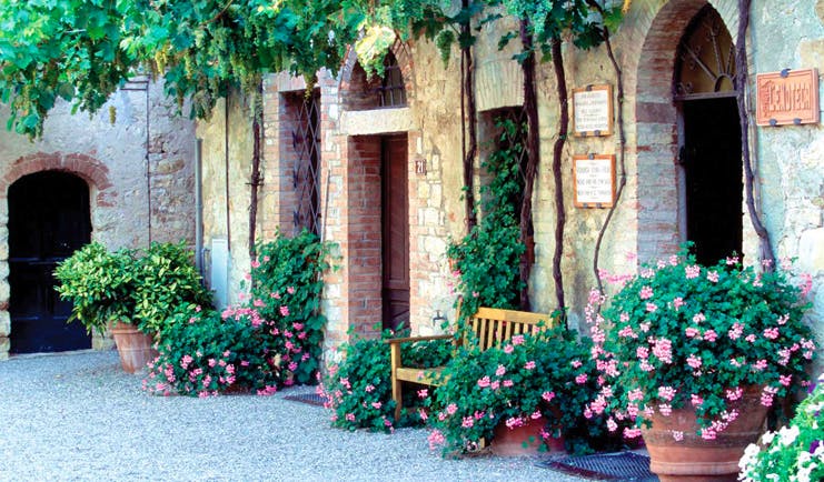 Hotel Borgo San Felice Tuscany courtyard bench flowers growing up wall