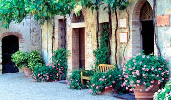 Hotel Borgo San Felice Tuscany courtyard bench flowers growing up wall