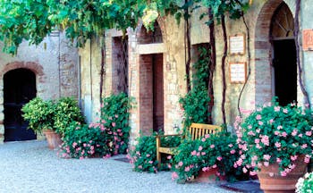 Hotel Borgo San Felice Tuscany courtyard bench flowers growing up wall