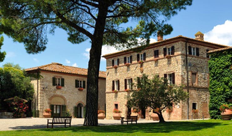 Hotel Borgo San Felice Tuscany exterior hotel building lawns trees benches