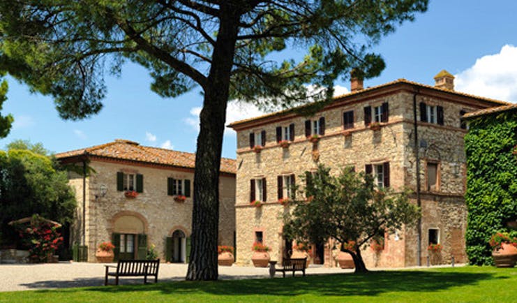 Hotel Borgo San Felice Tuscany exterior hotel building lawns trees benches