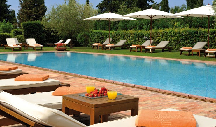 Hotel Borgo San Felice Tuscany pool sun loungers umbrellas