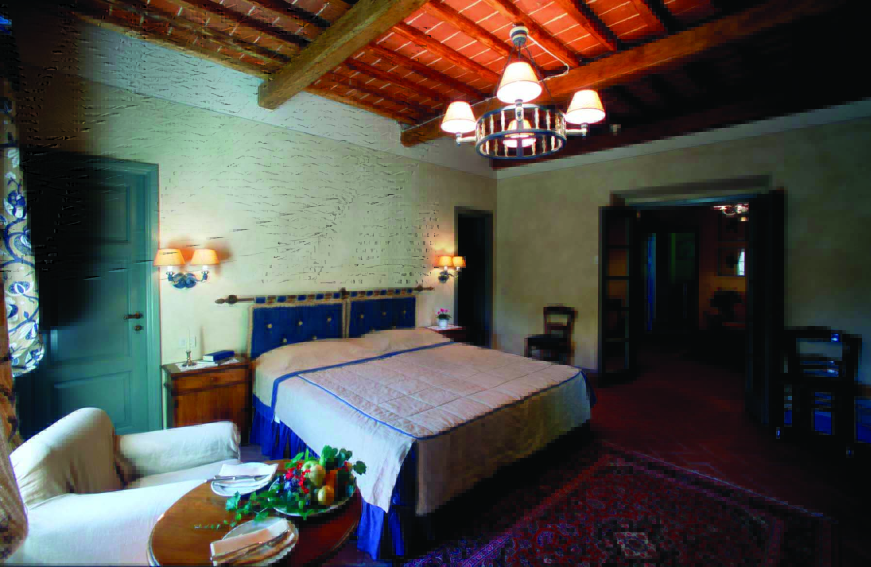 Hotel Borgo San Felice Tuscany suite bedroom armchair elegant décor