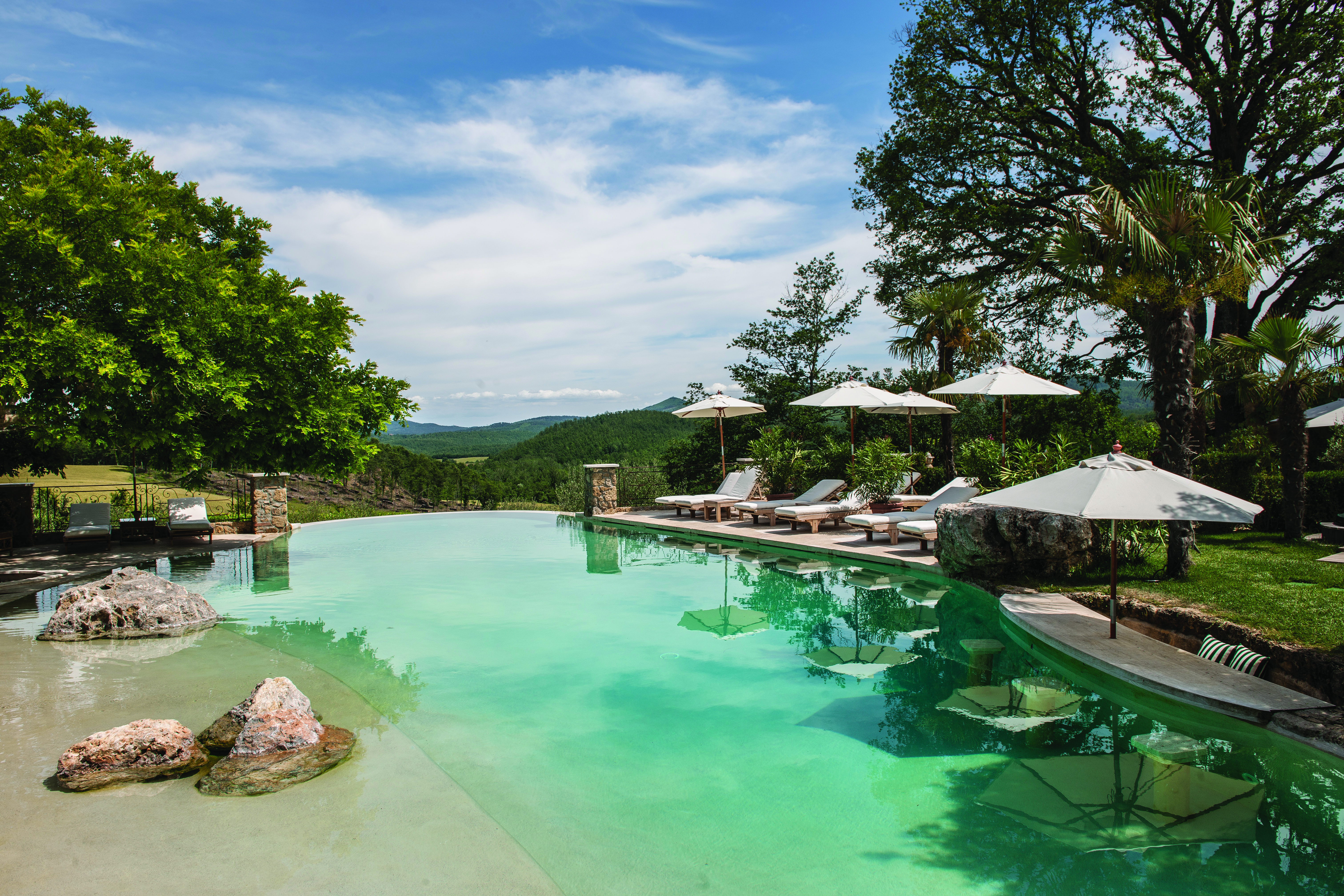 Borgo Santo Pietro Tuscany infinity pool area sun loungers views of countryside