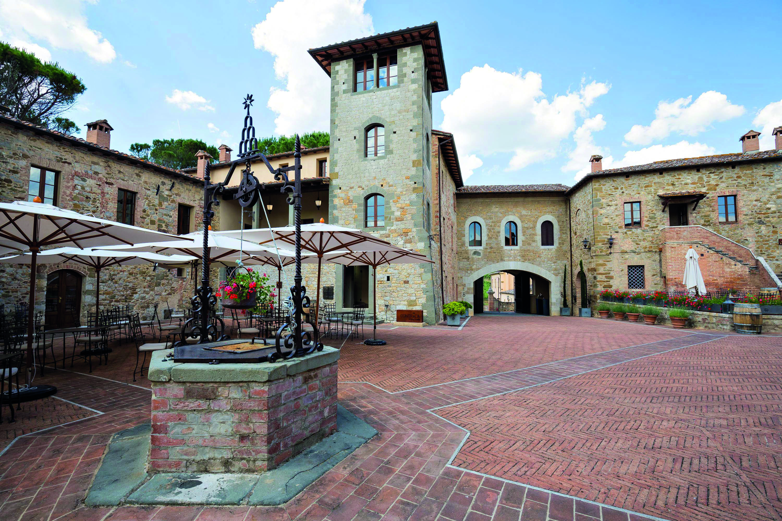 Castel Monastero Tuscany courtyard outdoor seating area surrounded by buildings