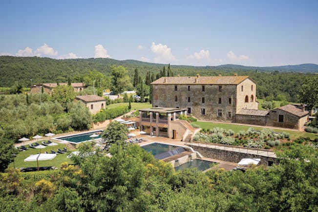 Castel Monastero Tuscany exterior shot pools hotel buildings surrounding countryside