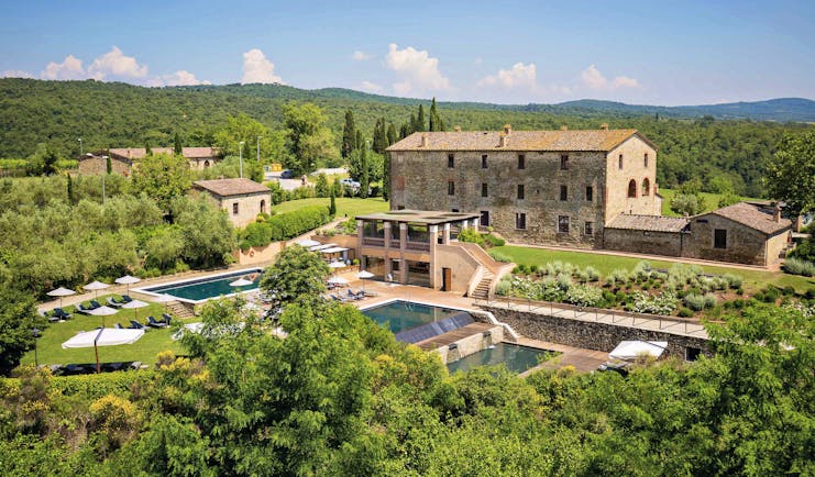 Castel Monastero Tuscany exterior shot pools hotel buildings surrounding countryside