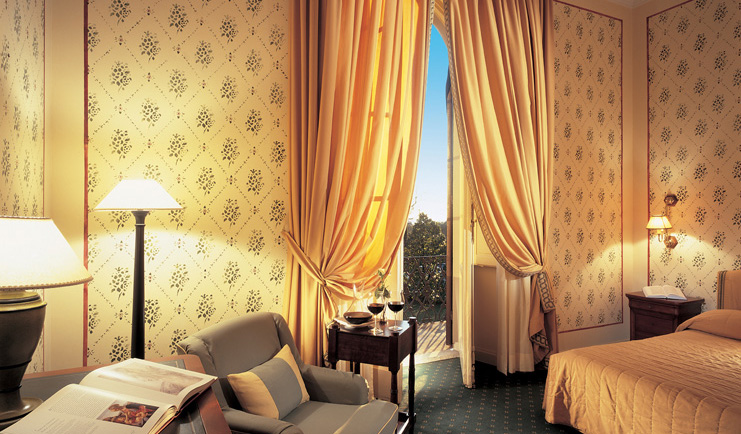 Grotta Giusti Tuscany deluxe room bed armchairs traditional décor