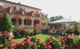 Hotel Le Renaie Tuscany lawns potted plants pink flowers hotel building in background