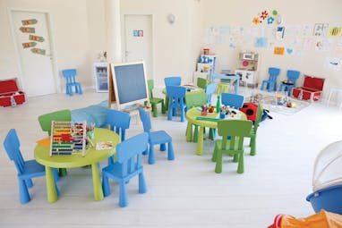 Kids club with playful toys around and multi-coloured small seats