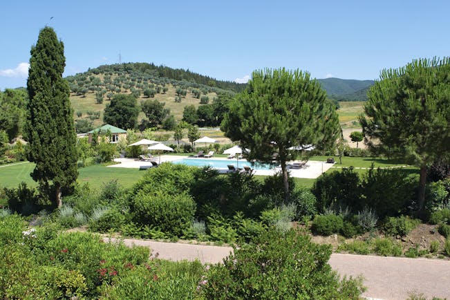 L Andana Tuscany pool sun loungers umbrellas views of countryside