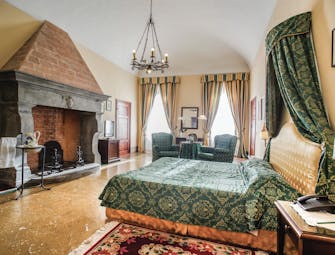 Palazzo Leopoldo Tuscany junior suite traditional décor bed seating fireplace