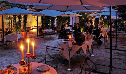 Relais dell'Orologio Pisa patio at night outdoor dining area tables chairs umbrellas candles