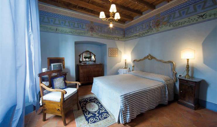 Bedroom with double bed, blue colour scheme and chandelier