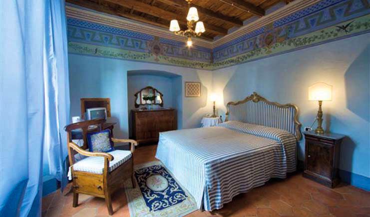 Bedroom with double bed, blue colour scheme and chandelier