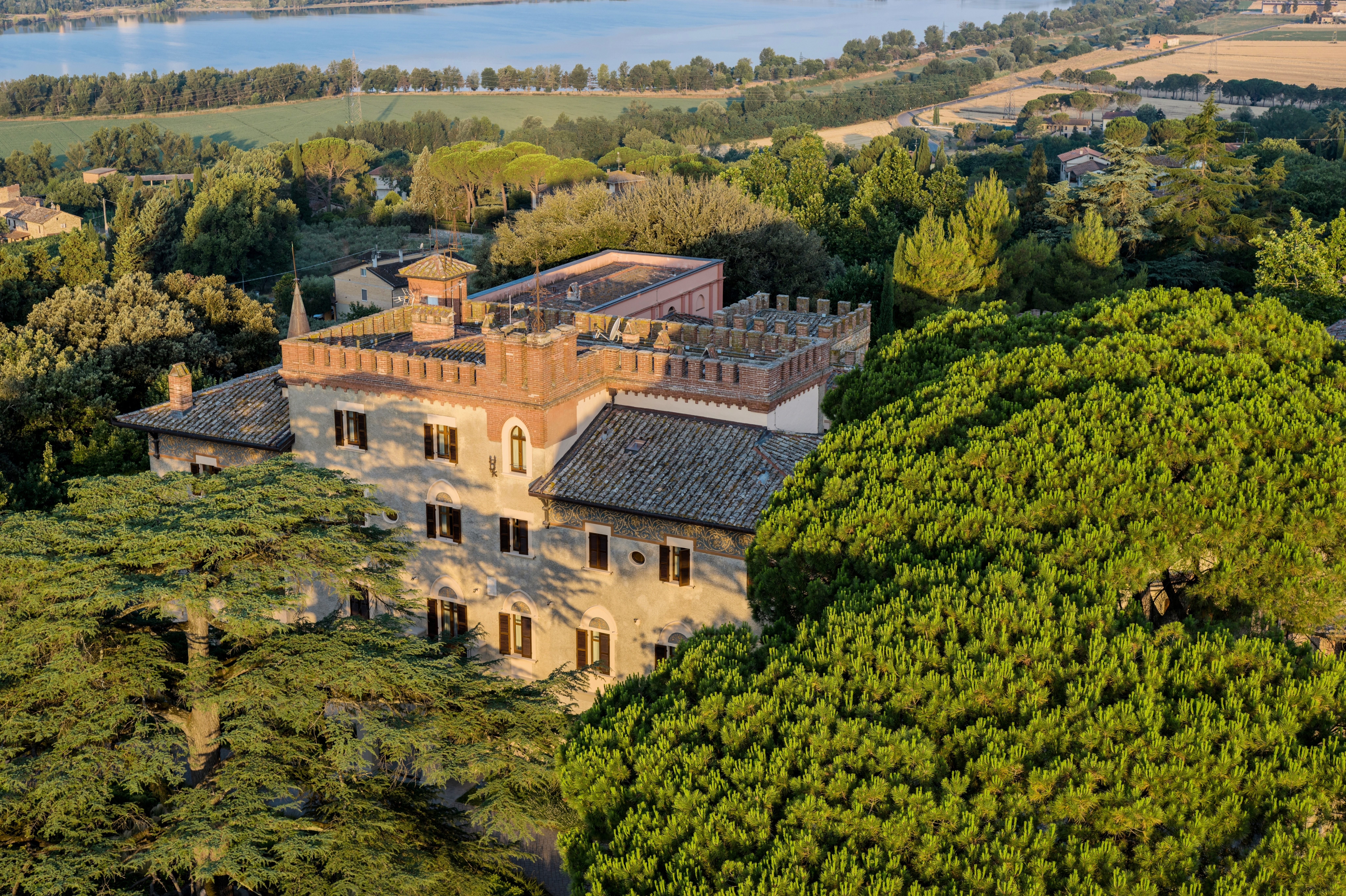 Borgo dei Conti aerial shot, showing the stone hotel building emerging from a sea of lush trees