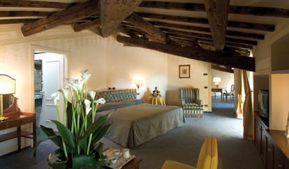 Hotel Brufani Palace Umbria deluxe room bed armchairs roof beams elegant décor