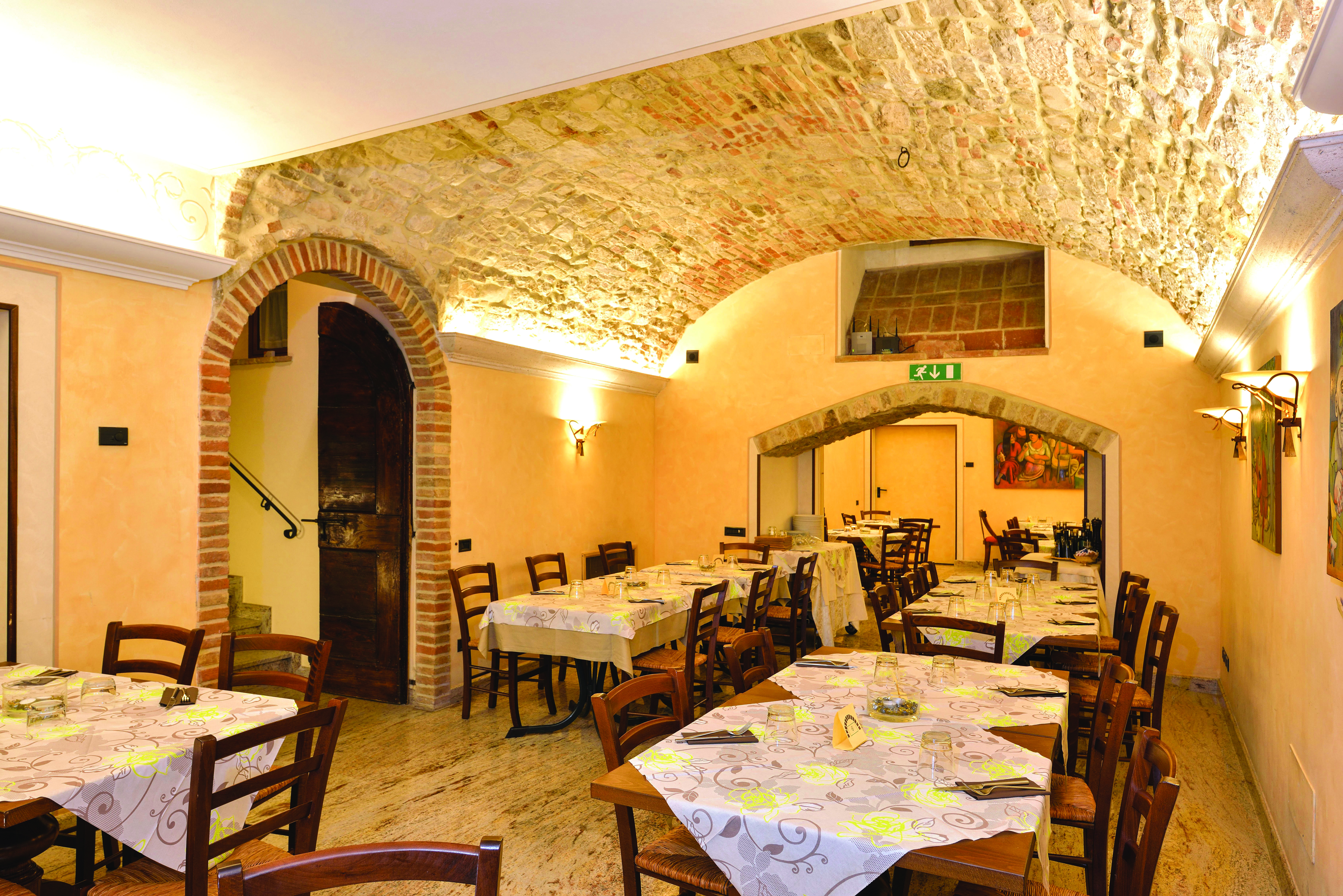 Yellow dining room with wooden tables and chairs laid out 