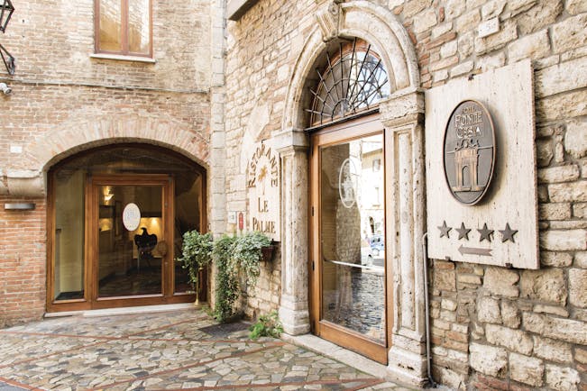 Hotel fonte cesia entrance with stone walls and big archway for door 