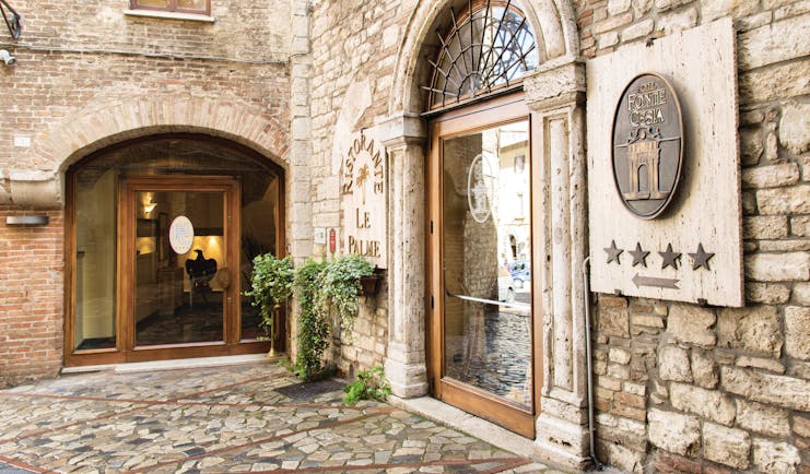 Hotel fonte cesia entrance with stone walls and big archway for door 
