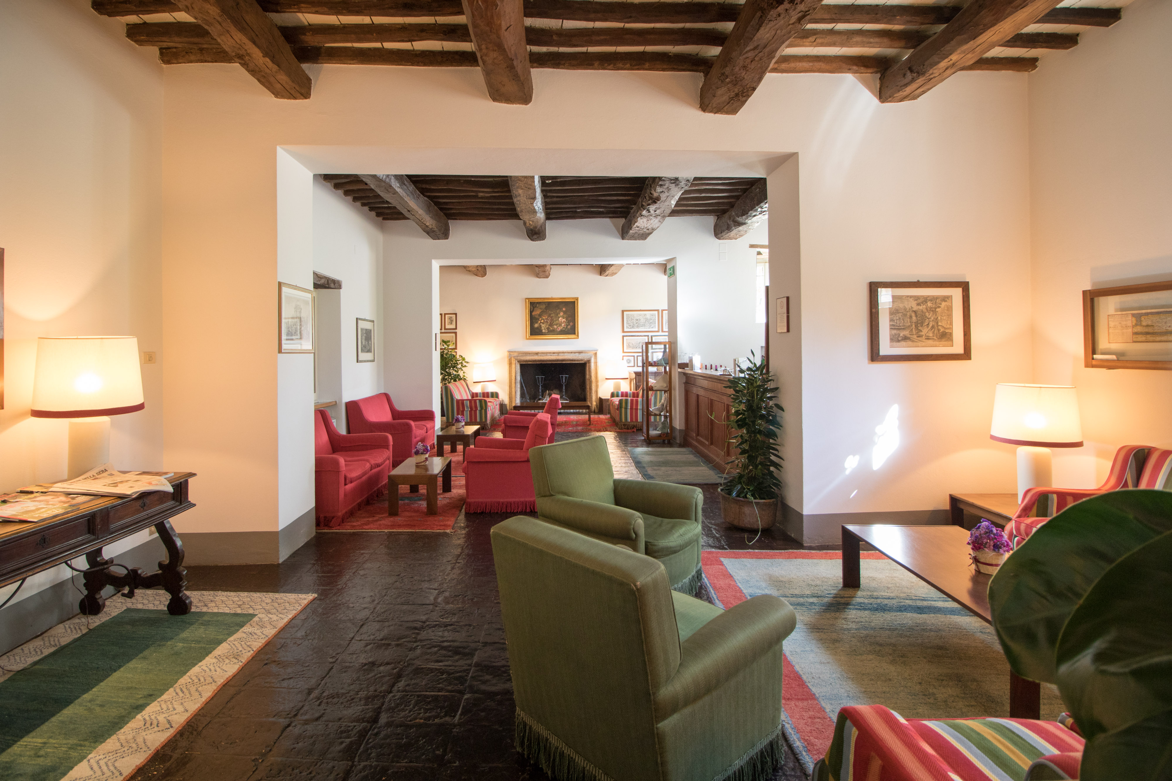 Room with wooden ceiling, green and red chairs
