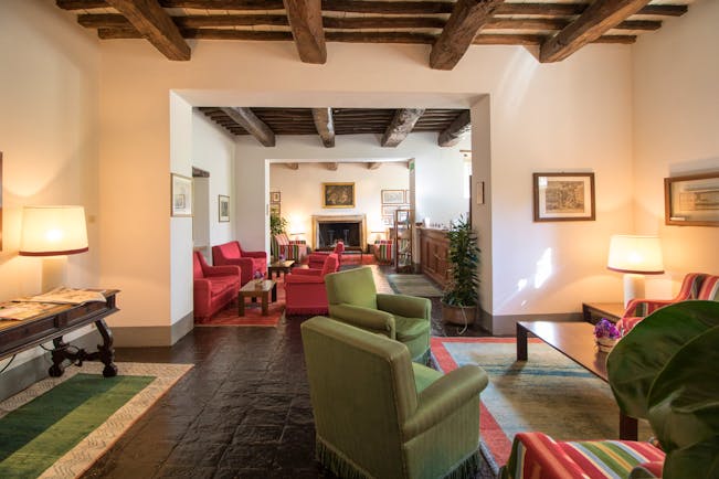 Room with wooden ceiling, green and red chairs