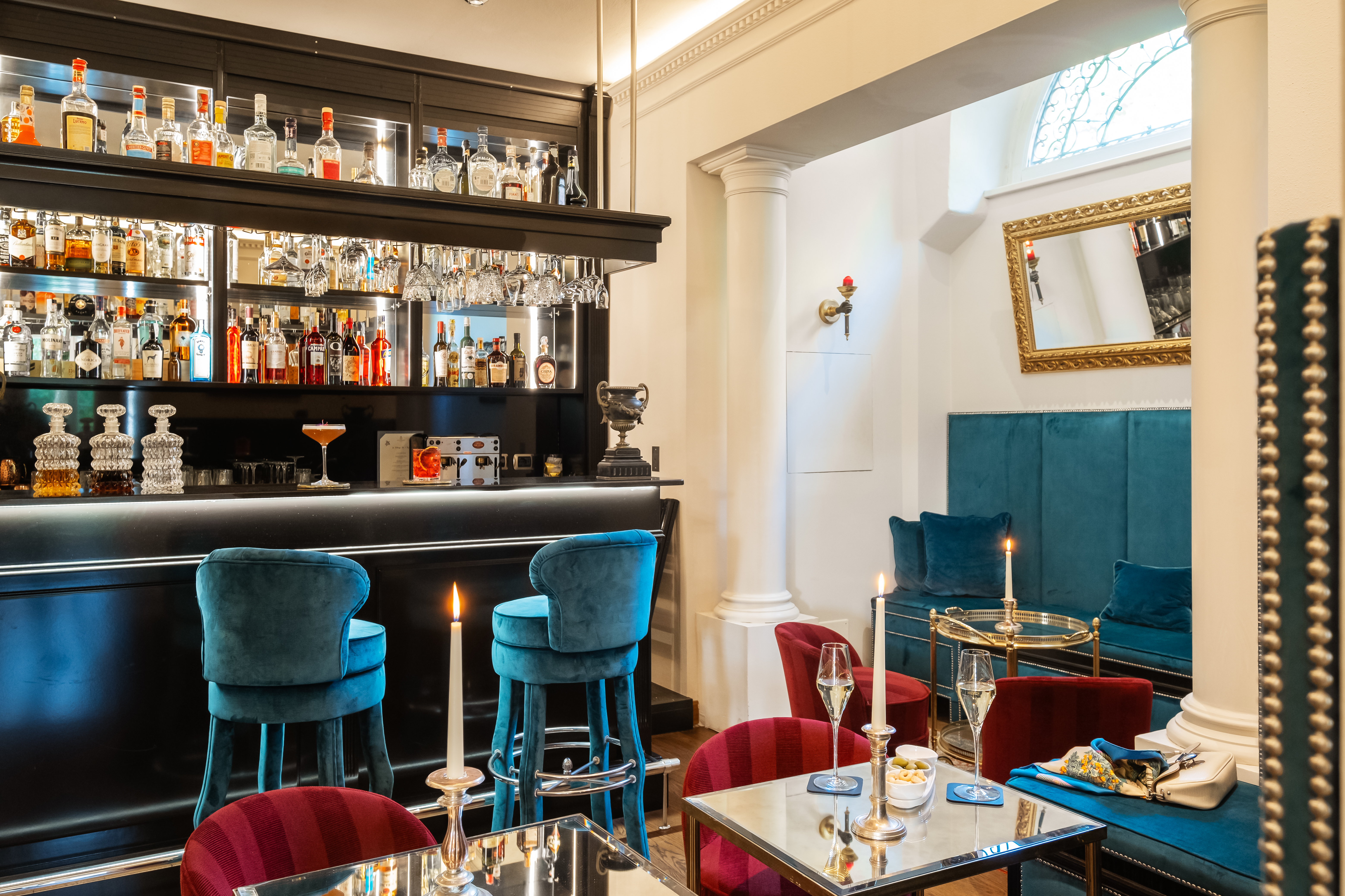 Hotel Vannucci La Tartaruga Bar and Cafe, with tall blue bar stools and custom booths, and red plush chairs