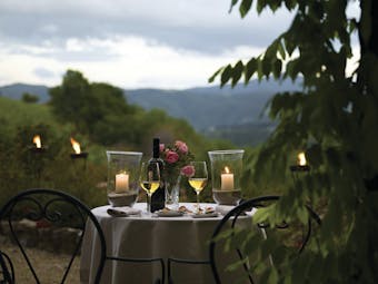 Dining experience at the Hotel Villa di monte solare with a candle lit dinner set up outside overlooking the mountains