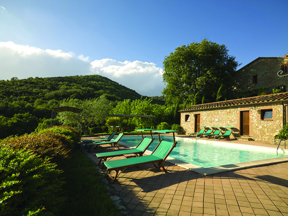 View of the pool from a different angle showing the blue sunbeds around the edge of the pool