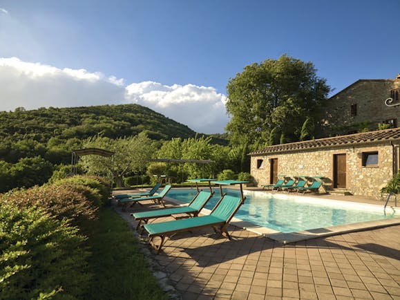 View of the pool from a different angle showing the blue sunbeds around the edge of the pool