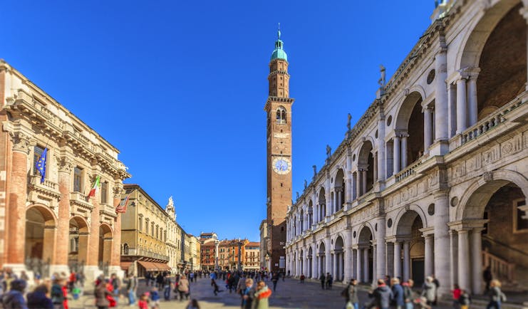 Tall campanile between arcaded buildings of Palladio in the Piazza dei Signori in Vicenza