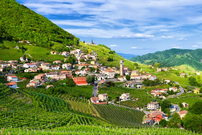 Prosecco wine vineyards in hill terraces with village in the Valdobbiadene Veneto