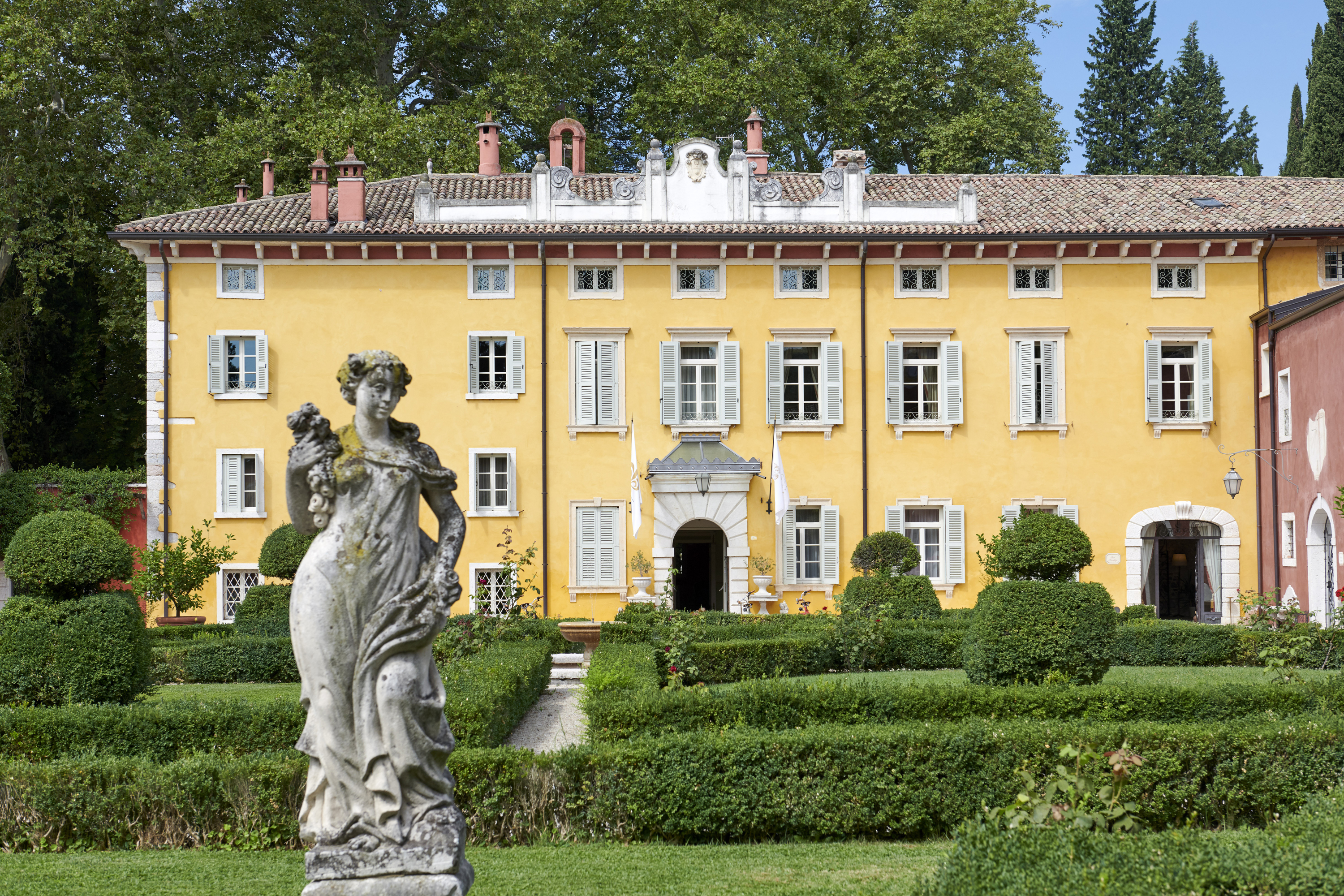 Villa Cordevigo yellow facade with statue of woman in foreground