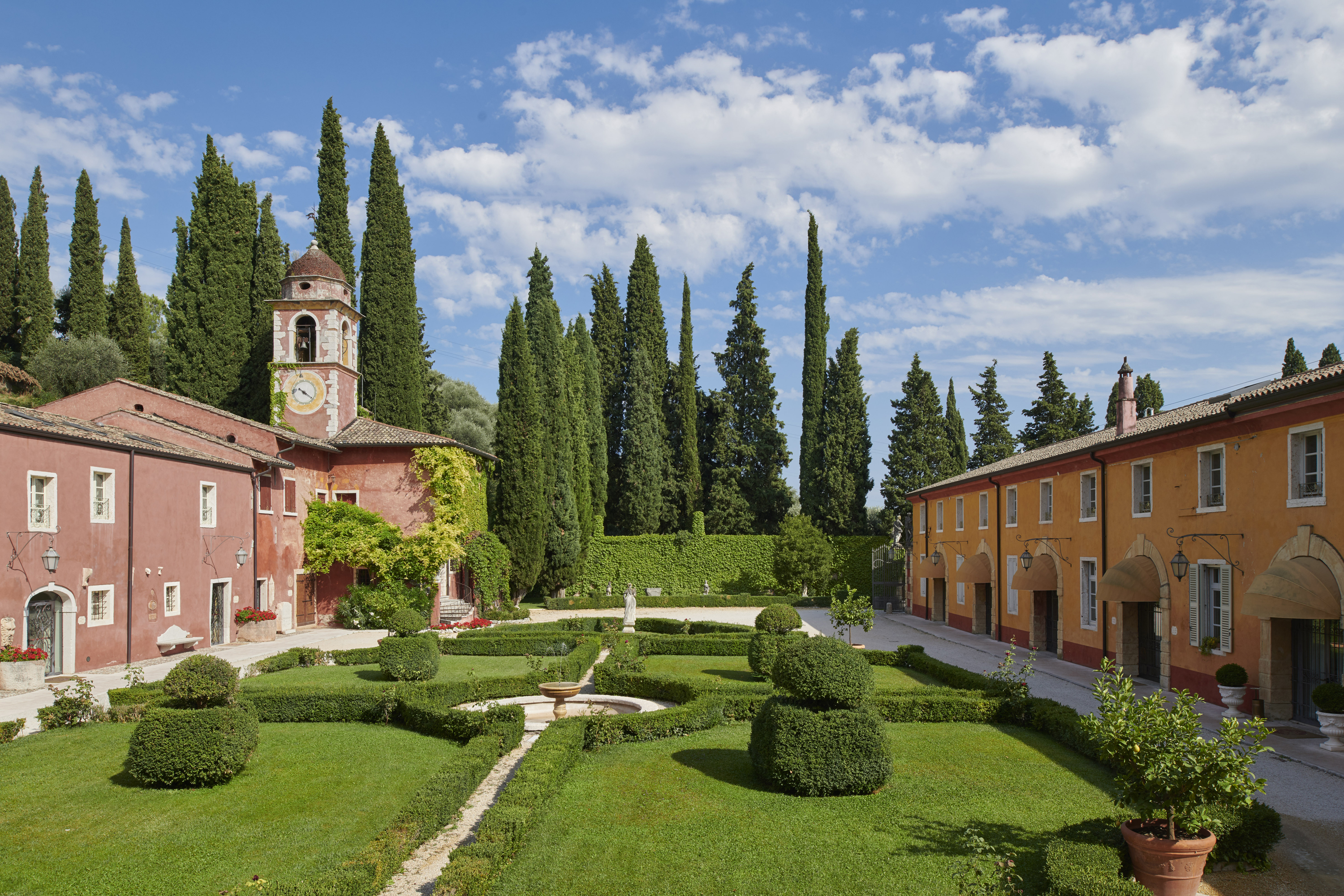 Villa Cordevigo with a pink turreted building on one side and a yellow building on the other