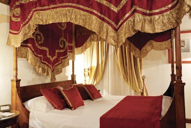 Villa Del Quar Veneto bedroom with four poster bed with red and gold colour scheme