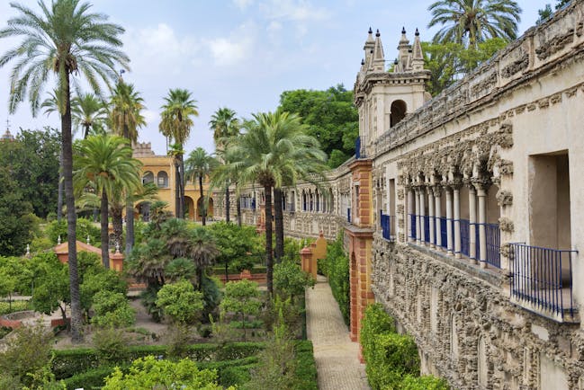 Palm trees and flower beds outside the walls of the Alcazar in Seville Andalusia