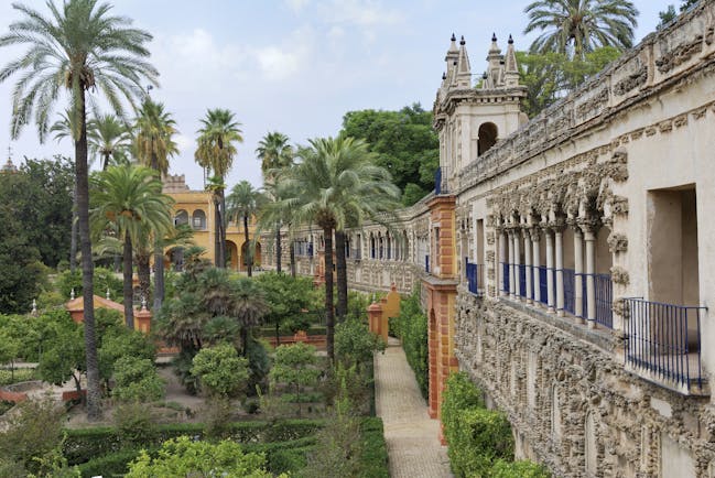 Palm trees and flower beds outside the walls of the Alcazar in Seville Andalusia