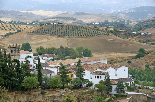 White washed village houses in landscape of yellow sunburnt fields at Ronda in Andalusia