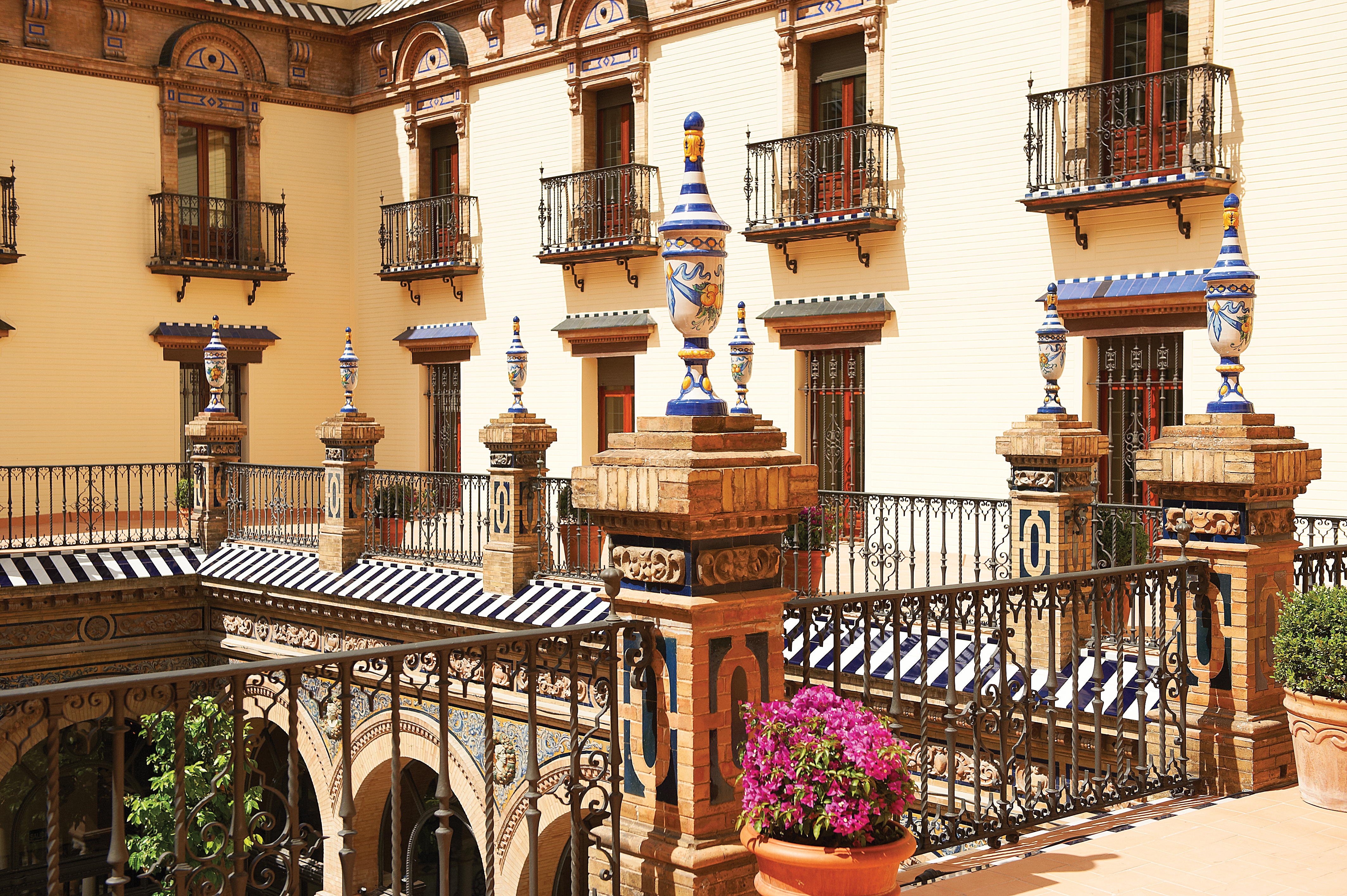 Courtyard with balcony surrounding and potted plants and flowers 