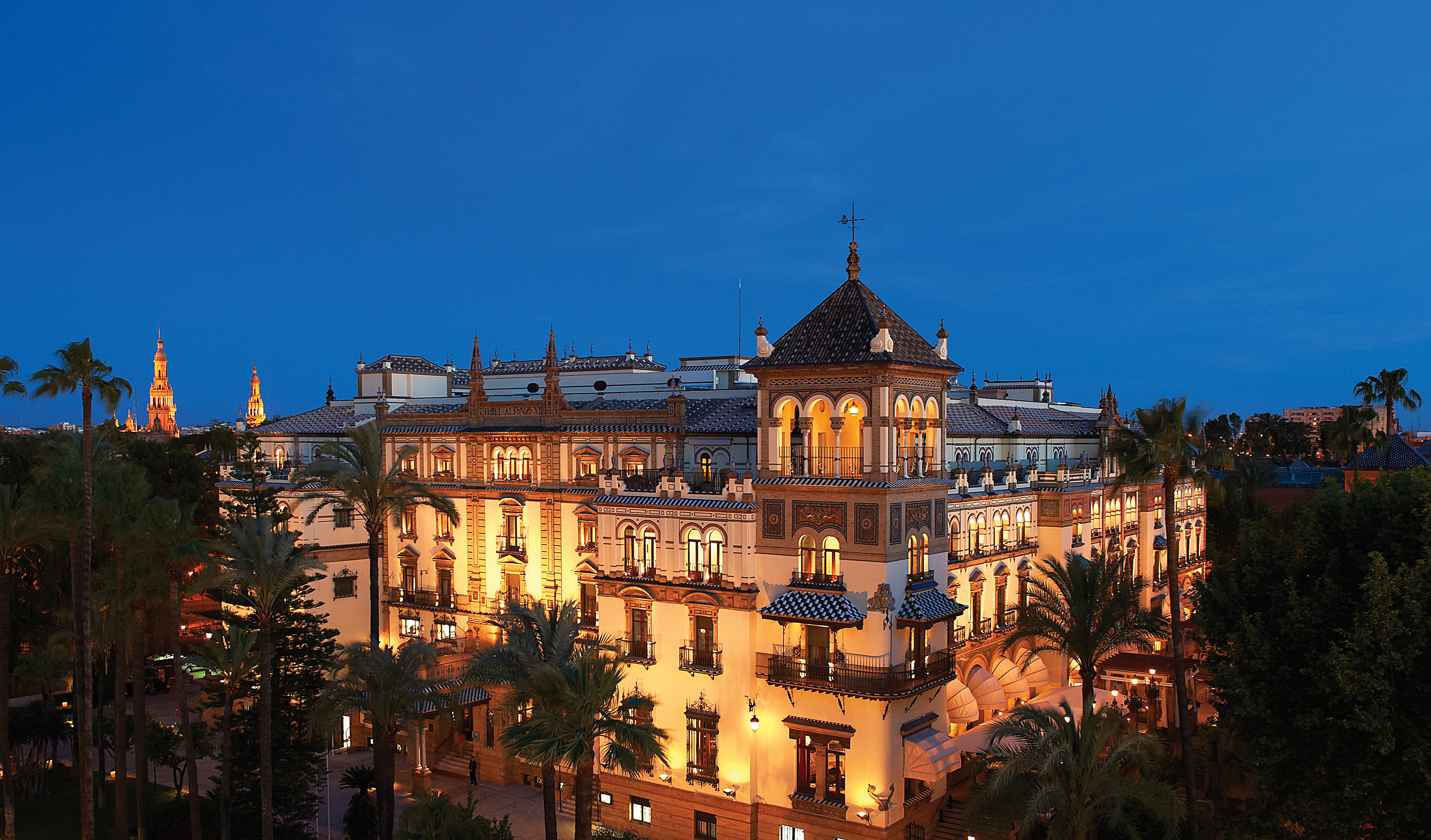 Hotel exterior at night with wall lamps lighting up the hotel building