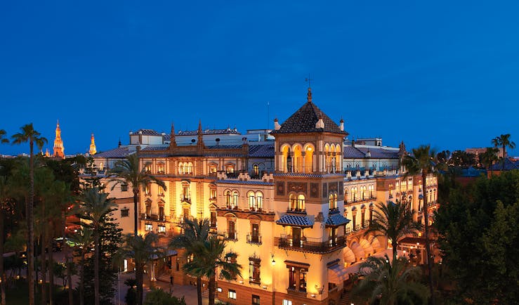 Hotel exterior at night with wall lamps lighting up the hotel building