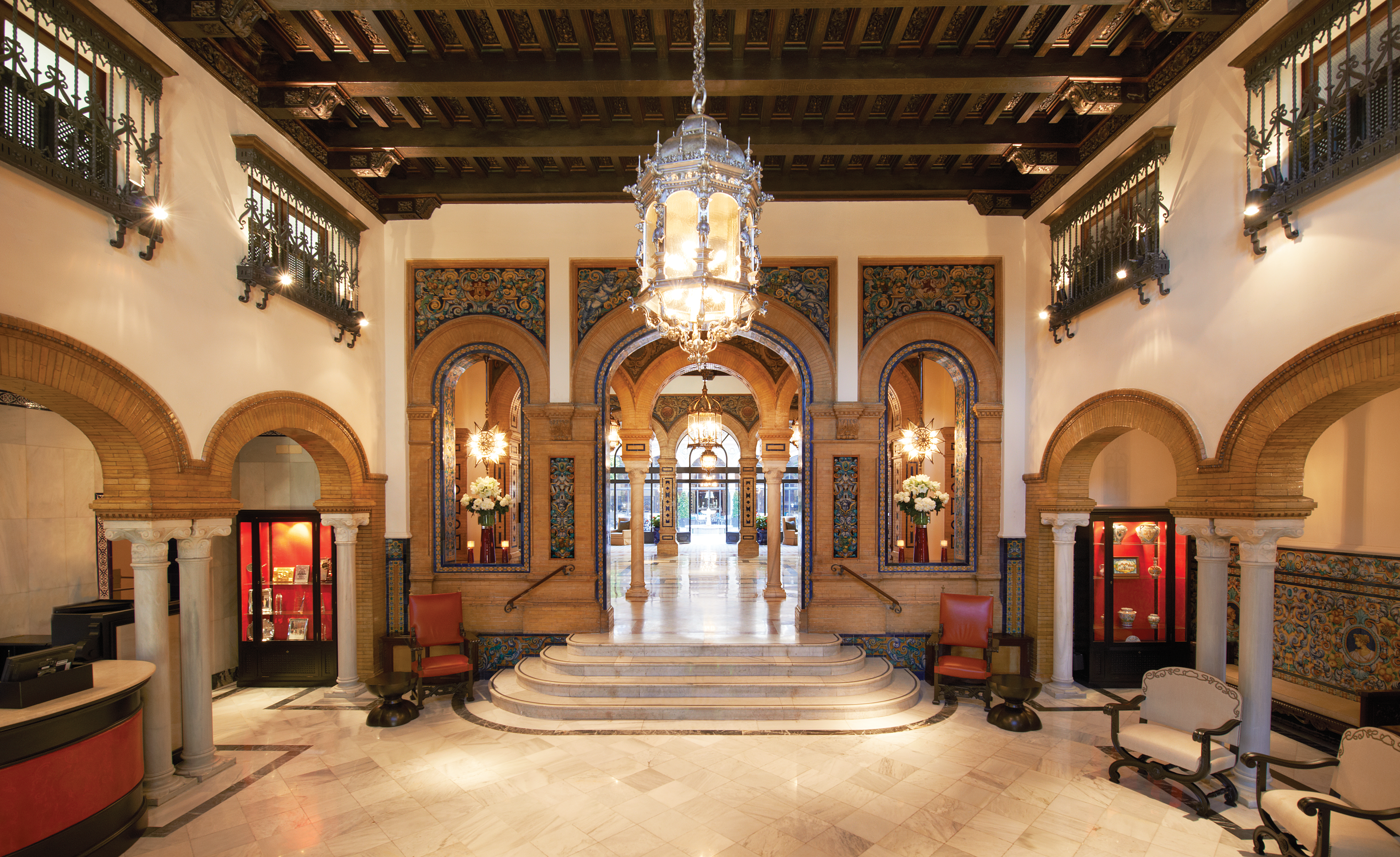 Hotel lobby with pillars, staircases and large chandelier