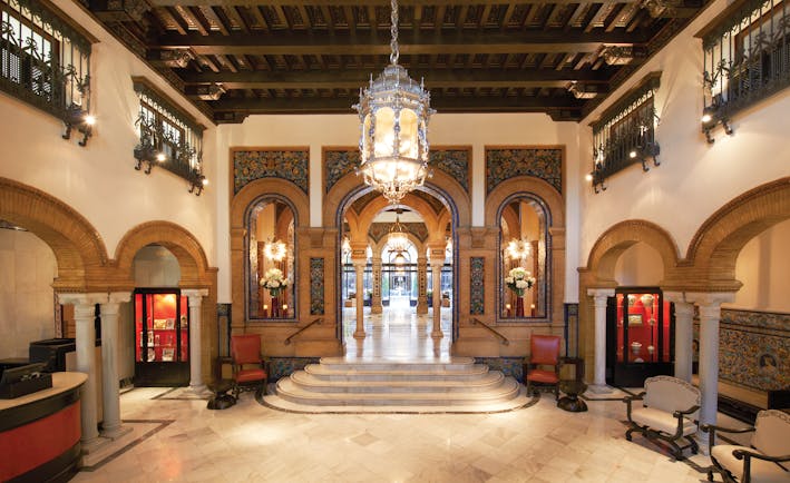 Hotel lobby with pillars, staircases and large chandelier