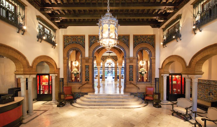 Hotel lobby with pillars, staircases and large chandelier