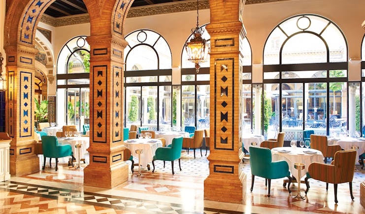 Restaurant with large arching pillars and dining table seating area 