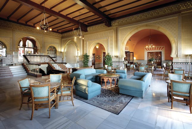 Hotel Alhambra Palace lobby with green and wooden seats 