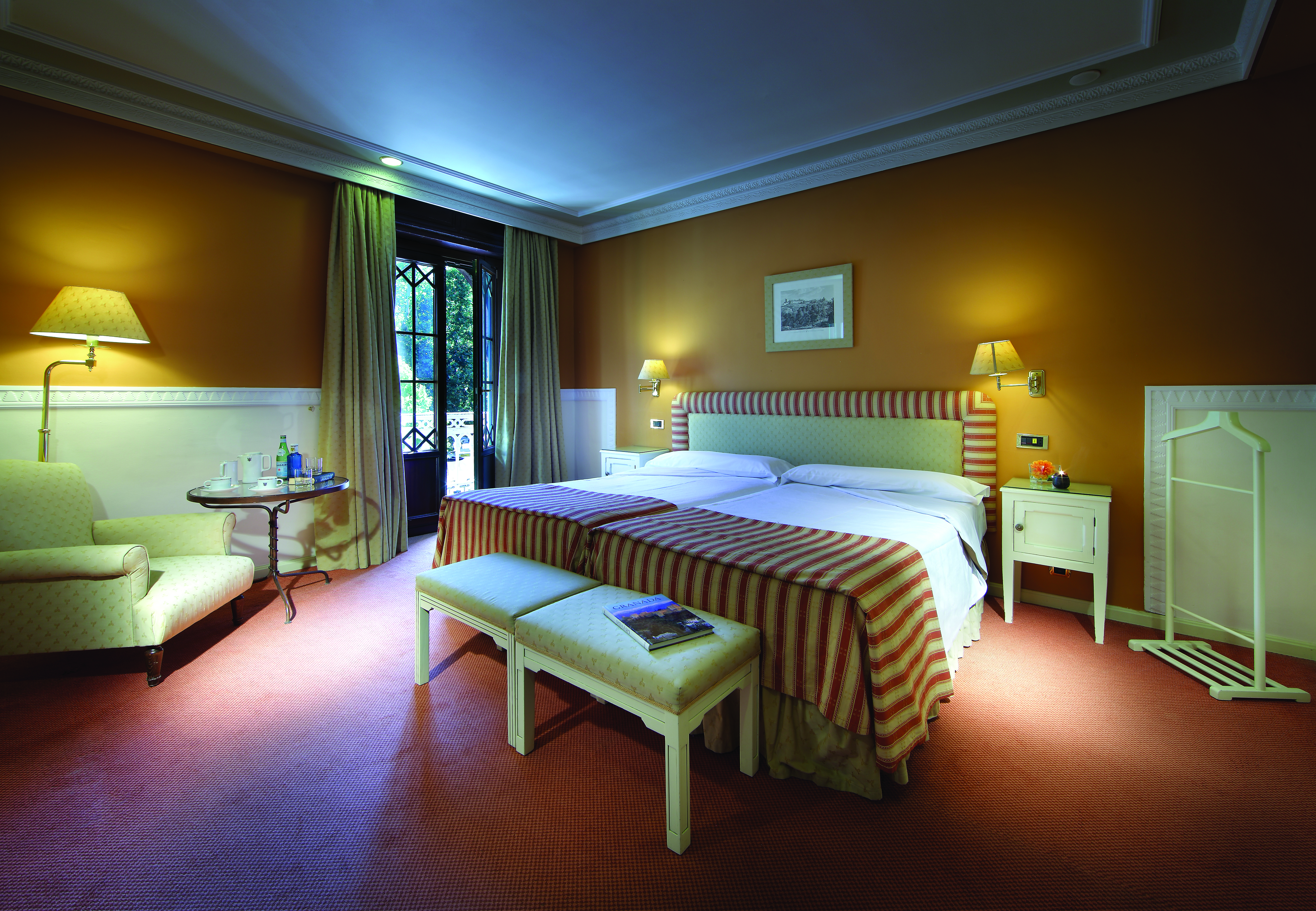 Twin room at the hotel Alhambra Palace with exterior views and a yellow and red colour scheme