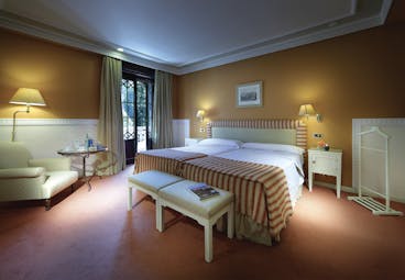 Twin room at the hotel Alhambra Palace with exterior views and a yellow and red colour scheme